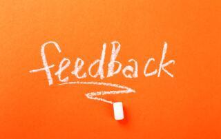 feedback-wort-mit-kreide-auf-orange-geschrieben. Bild von Racool_studio