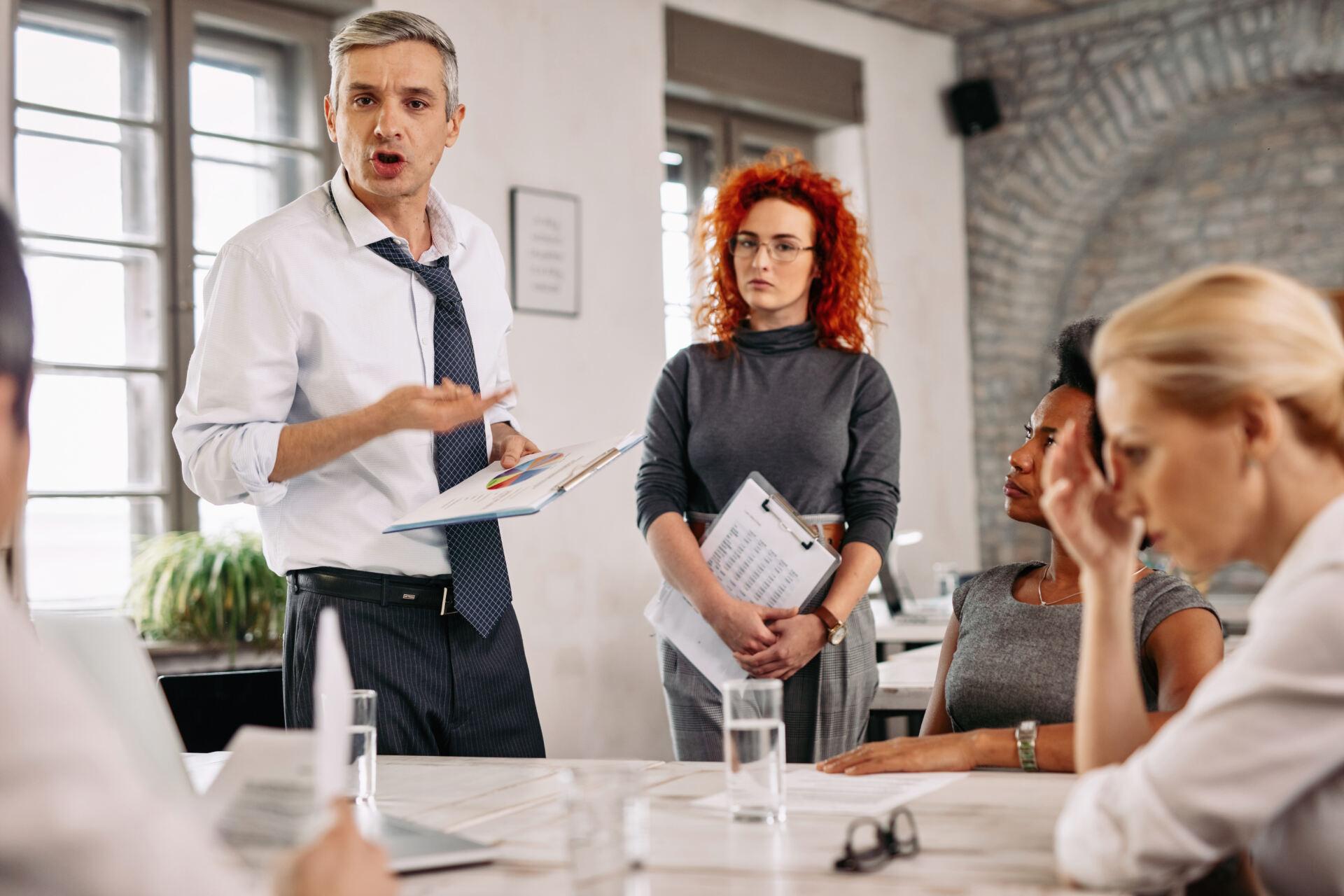 Angry businessman feeling disappointed with business reports and scolding his team during a meeting in the office. Bild von Drazen Zigic